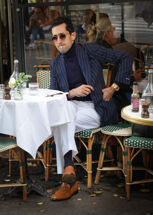 Man sitting at a table in an outdoor cafe setting