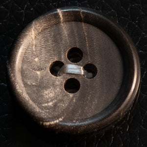 Close-up of a brown button on black leather