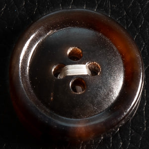 Close-up of a brown button on black leather