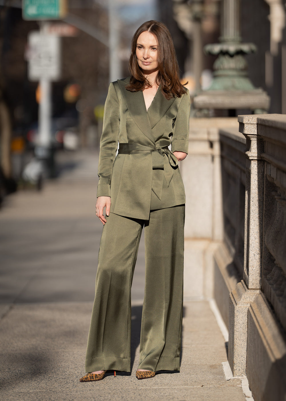 Woman in a brown suit standing in front of a blue door.