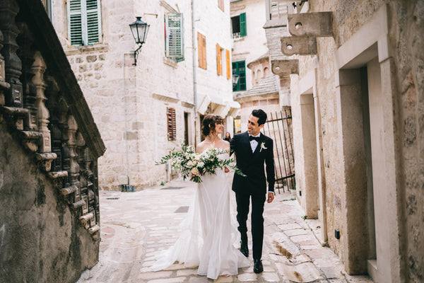 Couple walking through a narrow street with stone buildings